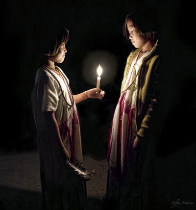 indigenous hilltribe karen hilltribe youth wearing white dresses are standing in complete darkness while looking at a candle