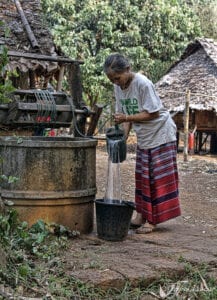 northern thailand hilltribes - jeffrey warner -nam bor noi karen village - woman pouring water from the well