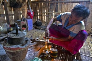 nam bor noi karen village - man lighting fire and with cell phone